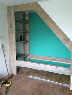 an unfinished bed frame in the corner of a room with blue walls and wood flooring