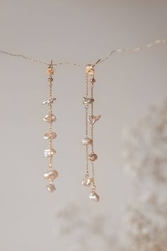 These handcrafted earrings feature two rows of Freshwater Pearls, each individually wrapped and suspended from a 14k 8cm gold-filled chain and secured with butterfly backings. Pair with the Safia necklace for a complete and coordinated look. Please note that, as we use only natural pearls, there may be slight variations in shape and shade. All our jewelry comes with a one-year guarantee valid from the date of delivery. Gold Pearl Jewelry With Dangling Beads, Yellow Gold Pearl Drop Dangle Chandelier Earrings, Elegant Double Strand 14k Gold Filled Jewelry, 14k Gold Dangle Pearl Earrings, Elegant Rose Gold Earrings With Dangling Beads, Luxury Pearl Chain Dangle Jewelry, Fine Jewelry Dangle Pearl Chain, Elegant Long Drop Chandelier Earrings With Dangling Charms, 14k Gold-filled Long Drop Jewelry With Pearl Charm