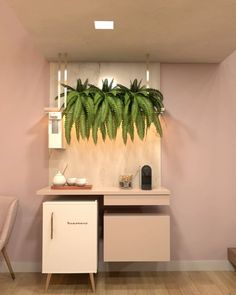 there is a plant on the wall in this room with pink walls and white furniture