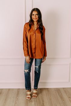 - This versatile top is perfect for a stylish look day or night! - Unlined material with a satin finish - A collared v-cut neckline - A button-up front - Long, loose sleeves with button closure cuffs - A relaxed silhouette that ends in a rounded hemline Trendy Satin Blouse For Fall, Casual Satin Blouse For Fall, Trendy Satin Tops For Fall, Casual Satin Tops For Fall, Fall Satin Blouse With Button Closure, Fall Button-up Satin Blouse, Satin Top With Button Closure, Solid Satin Top With Button Closure, Fall Satin Button-up Blouse