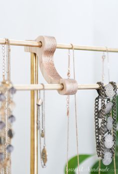 several necklaces are hanging on a wooden rack