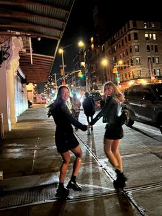 two young women are playing with each other on the sidewalk