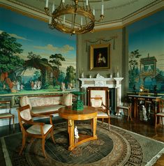 a living room filled with furniture and a painting on the wall next to a fire place