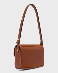 Tory Burch 'Robinson' shoulder bag in spazzolato patent leather.Adjustable shoulder strap.Flap top with snap closure; T monogram accent.Interior, one slip pocket.Lining: Polyurethane.Approx. 6.1'H x 8.3'W x 2.4'D.Imported Luxury Rectangular Saddle Bag With Adjustable Strap, Luxury Brown Saddle Bag With Turn-lock Closure, Luxury Tan Shoulder Bag With Adjustable Strap, Luxury Tan Satchel With Adjustable Strap, Chic Cognac Shoulder Bag With Turn-lock Closure, Tan Satchel Flap Bag With Adjustable Strap, Luxury Shoulder Bag With Adjustable Strap And Flap, Luxury Shoulder Bag With Flap And Adjustable Strap, Classic Rectangular Tan Shoulder Bag