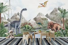 a child's room with dinosaur wallpaper and table and chairs in front of it