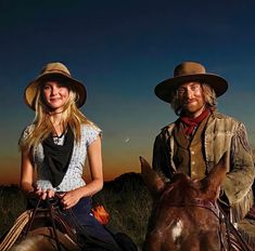 a man and woman riding on the backs of horses