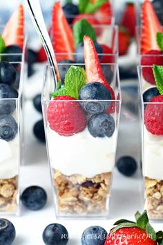 yogurt parfaits with berries and blueberries in small glass cups on a table