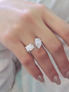 a woman's hand with two engagement rings on it