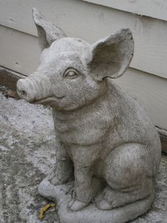 a statue of a pig sitting in front of a house