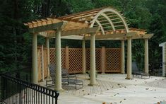 a wooden deck with chairs and trellis on it