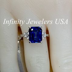 "This ring is an emerald cut lab created blue sapphire with round moissanite sides, 14k white gold # 6312 We feature the finest quality of lab grown sapphires in the world. The properties of lab-grown are physically, chemically and visually identical to natural, just grown in a lab setting. -Approximate total carat weight: 3.85ctw. diamond equivalent -Center Stone Size: approx. 3.55ct. diamond equivalent -Center Stone Shape: emerald cut 10x8mm -Gem Type: lab created blue sapphire -Stone Clarity: Blue Radiant Cut Lab-created Sapphire Jewelry, Fine Jewelry Emerald Cut Diamond Ring With Lab-created Sapphire, Blue Radiant Cut Sapphire Ring In Sterling Silver, Blue Sapphire Emerald Cut Promise Ring, Classic Blue Radiant Cut Emerald Ring, Blue Radiant-cut Emerald Ring In Fine Jewelry Style, Blue Radiant Cut Emerald Ring In Fine Jewelry, Blue Sapphire Radiant Cut Promise Ring, Blue Radiant Cut Emerald Ring Fine Jewelry