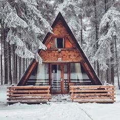 a cabin in the woods with snow on the ground