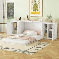 a white bed sitting on top of a hard wood floor next to a book shelf