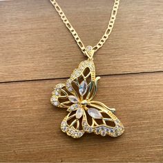 This One Of A Kind Butterfly Gold Plated Necklace In White Cubic Zirconia And White Cubic Zirconias All Around It. It’s Beautiful And Eye Catching, Be Ready To Receive Many Compliments Every Time You Wear It. Hypoallergenic Lead And Nickel Free Pendant Width 1 1/2” Chain Length 20” You Will Receive It In A Nice Little Box Ready To Gift. Este Exclusivo Collar De Mariposa En Oro Laminado Con Zirconia Cbica Blancas Es Hermoso Y Llamativo, Preprate Para Recibir Muchos Elogios Cada Vez Que Lo Uses. H Wedding Jewelry With Butterfly Charm In Cubic Zirconia, Wedding Jewelry With Cubic Zirconia Butterfly Charm, Jeweled Cubic Zirconia Necklaces For Gifts, Jeweled Cubic Zirconia Necklace Gift, Cubic Zirconia Jeweled Necklace Gift, Gold Butterfly Charm Jewelry For Party, Gold Butterfly-shaped Crystal Jewelry, Gold Jewelry With Butterfly Charm For Party, Gold Crystal Butterfly Jewelry