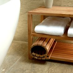 a wooden shelf with two white towels on top of it and a vase next to it