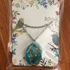 the necklace is in its package with chain and flower designs on it, as well as other items