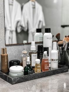 the bathroom counter has many different types of cosmetics and personal care items on it in front of a mirror