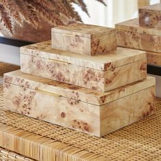 three wooden boxes sitting on top of a wicker table next to a planter