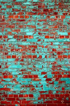 an old brick wall is painted blue and red