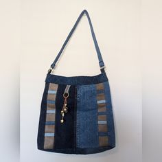 a denim bag hanging on the wall with a keychain in it's pocket