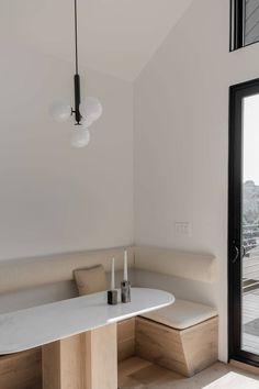 a table and bench in a room with glass doors leading to the outside deck area