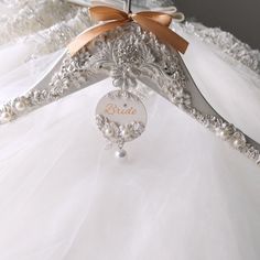 a white wedding dress with a brown bow on the back and name tag attached to it