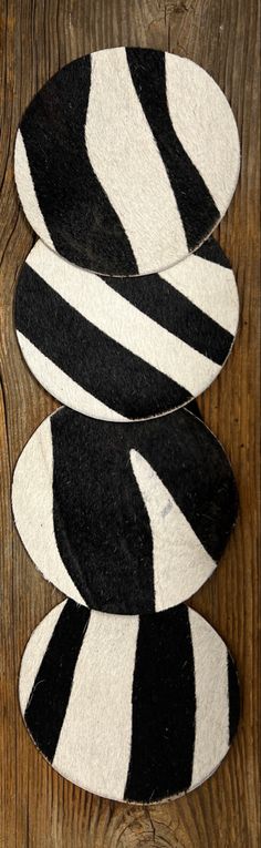 three black and white striped rugs sitting on top of a wooden floor