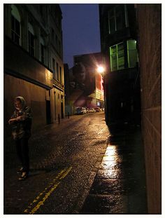 a woman walking down the street at night