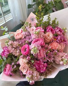 a bouquet of pink flowers sitting on top of a table