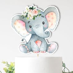 an elephant cake topper with flowers on it