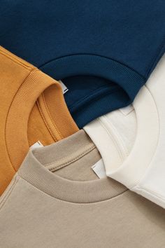 four different colored shirts stacked on top of each other