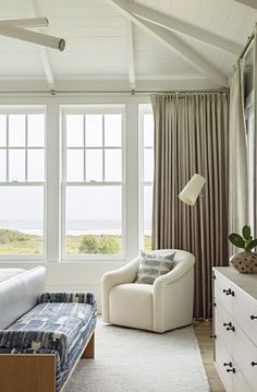 a bedroom with a bed, chair and large window in it's center area