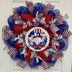 a red, white and blue wreath with an elephant on the center is hanging on a door