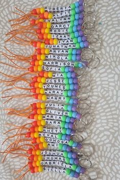 a rainbow colored keychain with words written on it and tassels attached to the keys