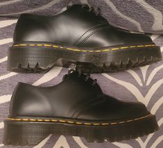 Dr. Martens Bex 21084 is a combat-style ankle boot with a lace-up closure and a round toe shape. The upper is made of black smooth leather, while the lining is made of leather and the insole is made of foam. The outsole is made of rubber and has a platform height of 1.5 inches. It has a flat heel style and a standard shoe width. This model is part of the Dr. Martens 1461 product line and is available in women's size 5 and men's size 4. THIS WAS STORE DISPLAY AND MIGHT HAVE BEEN TRIED ON...LOOKS BRAND NEW Doc Martens Platform Boots Mens, Leather Footbed Lace-up Oxfords For Streetwear, 1461 Smooth Leather Platform Shoes, Low Doc Martens, Dr Martens Bex, Doc Martens Black, Womens Booties, Combat Style, Low Shoes