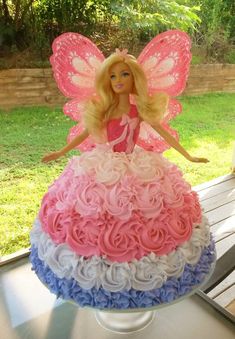 a barbie doll sitting on top of a cake