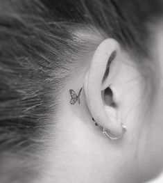 a small butterfly tattoo behind the ear