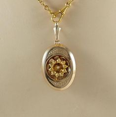 A delightful antique Victorian sentimental oval brooch/pendant, in gold filled, rolled gold, in a pale rose gold tone.  With a central daisy or margarite flower head, on a reticulated ground to top and bottom. The flower in yellow gold tone. With a simple  brooch fastening and a large bail for wearing as a pendant. The chain is for display only. Germany 1870s. 8g The brooch/pendant 3.5cm x 2.6cm.  In inches  1 1/4" x 1 1 /8". With bail 5.2cm.   In inches 2 1/8". VERY GOOD ANTIQUE CONDITION: THE Victorian Flower Pendant Jewelry Gift, Antique Jewelry With Intricate Flower Pendant, Victorian Yellow Gold Flower Pendant Jewelry, Victorian Gold Brooch With Locket, Victorian Gold Pendant Charms, Victorian Pendants, Rose Pale, Antique Brooches, Locket