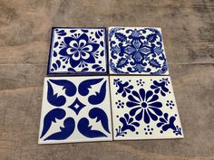 four blue and white tiles sitting on top of a wooden floor