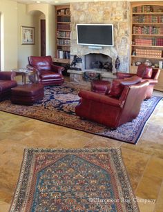 a living room filled with lots of furniture and a tv mounted to the wall over a fire place