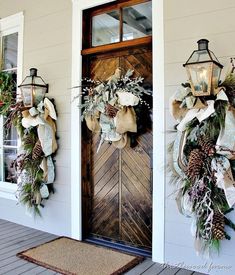 two wreaths on the front door of a house with christmas decorations hanging from them