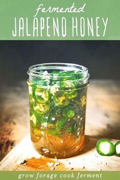 a jar filled with pickles sitting on top of a wooden cutting board