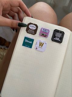 a person holding a notebook with stickers on it