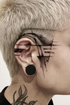 a woman with tattoos on her face and behind the ear is a piece of artwork