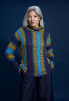 an older woman with grey hair wearing a multicolored sweater