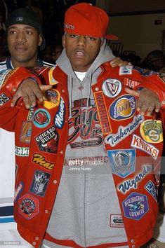 two men in red jackets and hats posing for the camera with badges on their coats