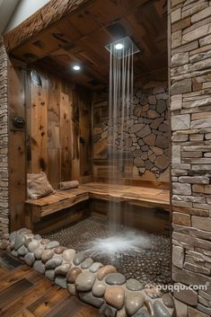 a spa room with stone walls and wooden flooring, water flowing from the shower head