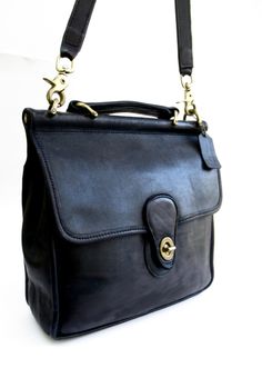 before you is an  classic,  crossbody,  willis station,   coach bag made in the United States of black leather with brass findings.       this vintage bag would work well for around town or a day of shopping,   easy and breezy with just the right amount of storage.     this  turn lock,  top handle,  station bag  is classic coach,     timeless.       at about 10.5 inches wide and 10 inches tall,  with a  44 inch strap that is detachable and adjustable.  the turn lock works well.     for vintage, this bag is in nice shape,  the outside looks good with minor scuffing that would be expected with a bag of its age,  the inside is clean.   so,    if you are looking for a classic black leather coach,   an original classic,    this is the bag for you! Vintage Satchel With Metal Hardware For Everyday, Classic Satchel With Brass Hardware In Tote Shape, Classic Tote Satchel With Brass Hardware, Vintage Everyday Satchel With Metal Hardware, Classic Satchel Tote With Brass Hardware, Classic Satchel With Brass Hardware, Vintage Satchel Briefcase With Gold-tone Hardware, Classic Vintage Black Bag For Everyday Use, Classic Vintage Black Bag For Daily Use