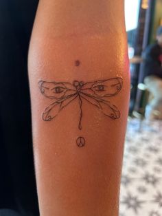 a woman's leg with a tattoo on it that has a dragonfly drawn on it