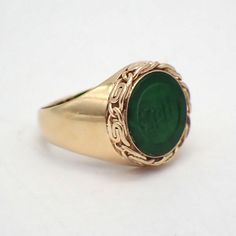 Vintage 14k (.585) yellow gold round form signet ring with a green Jade inset, featuring carved symbols, and outlined with ornate bezel. This glorious ring is a size 5, it is 13.2 mm wide, weighing 4.2 grams. EA4848 Green Oval Signet Ring For Wedding, Oval Green Signet Ring For Wedding, Green 14k Gold Signet Ring With Bezel Setting, Formal Green Oval Signet Ring, Green Bezel Set Signet Ring For Wedding, Green Signet Ring With Bezel Setting For Wedding, Green 14k Stamped Signet Ring, Green Oval Heirloom Signet Ring, Heirloom Green Oval Signet Ring